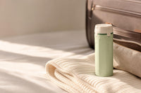 Bottly Kit en verde y blanco junto al equipaje de viaje